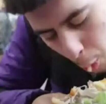 Joven disfruta la rica hamburguesa frente a los veganos Joven disfruta la rica hamburguesa frente a los veganos