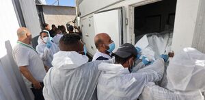 Trabajadores de la morgue descargan los cuerpos de palestinos. (AFP)