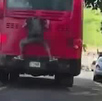 Hombre viaja colgado en parte trasera de un bus