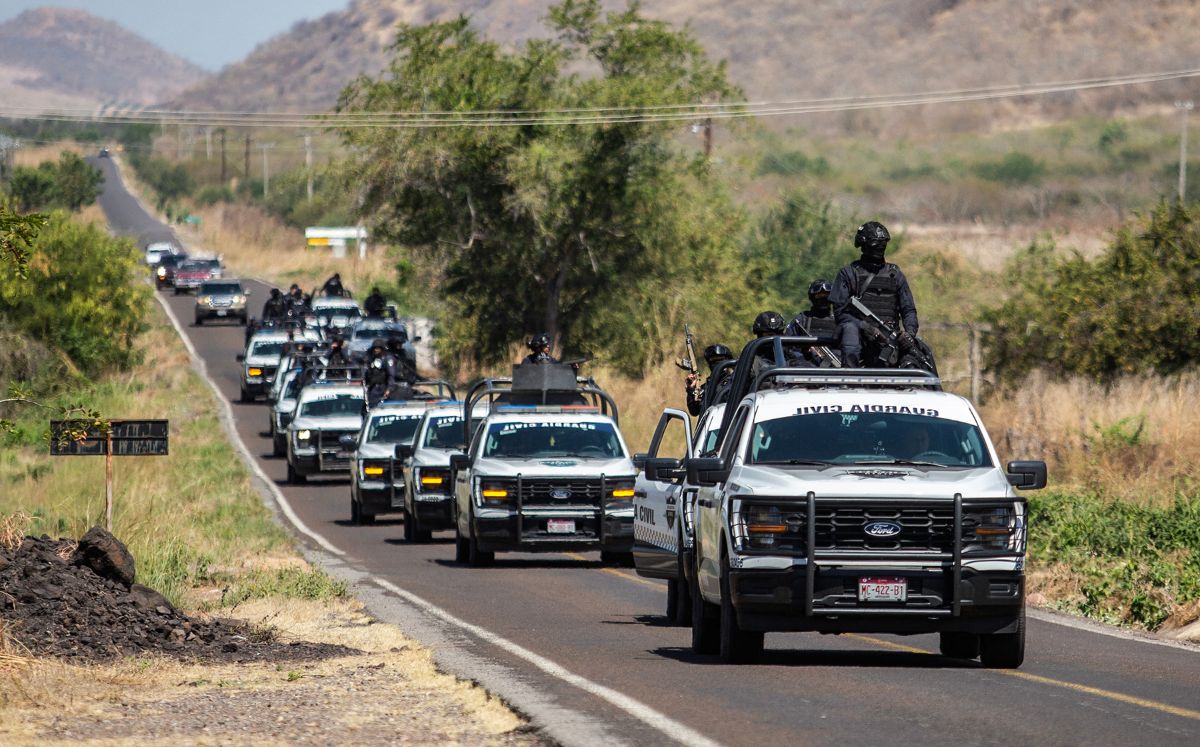 Elementos de la Guardia Civil de Michoacán patrullan una carretera apoyados por vehículos blindados. (AFP)